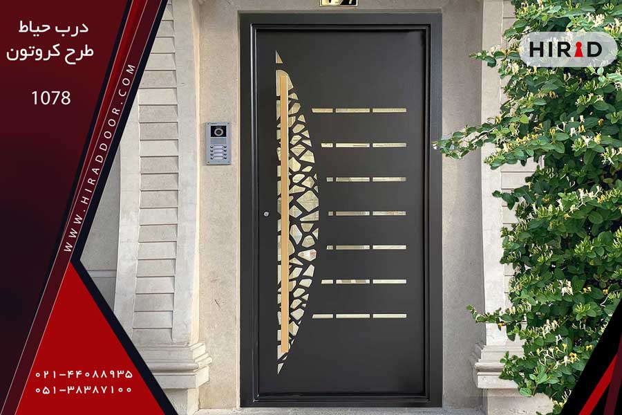 درب حیاط تک لنگه سیاه، با برش کمانی بلند شبیه نیم دایره در قسمت دستگیره، نصب شده در ورودی ساختمان جنوبی با نمای سنگ مرمر